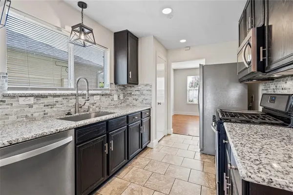 a kitchen with stainless steel appliances granite countertop a sink stove and refrigerator