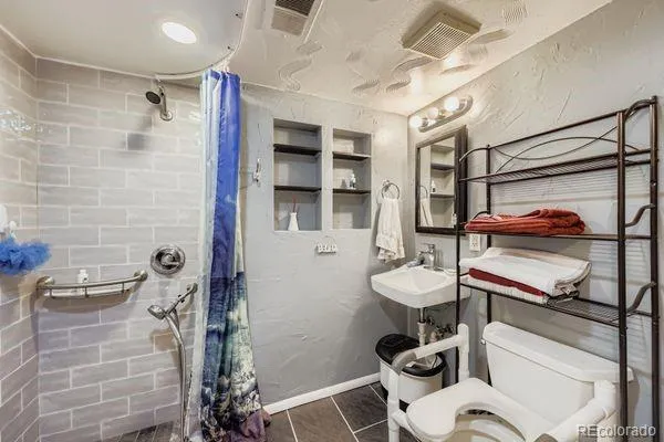 a bathroom with a sink toilet and shower