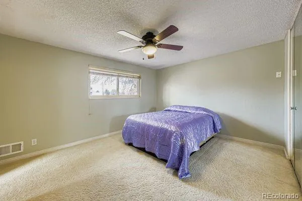 a spacious bedroom with a bed and a chandelier