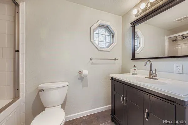 a bathroom with a toilet a sink a mirror and vanity