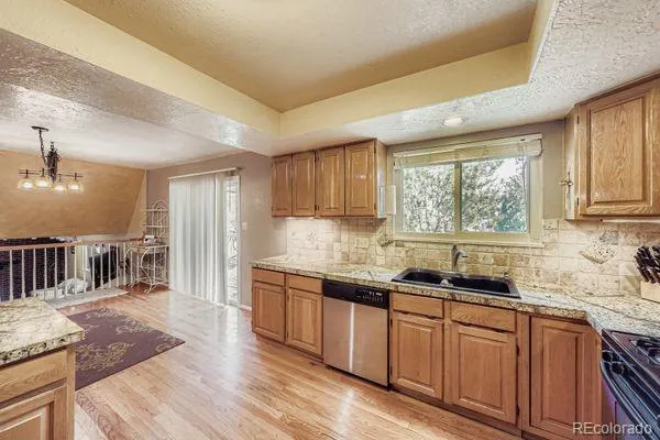 a kitchen with granite countertop a sink window and cabinets