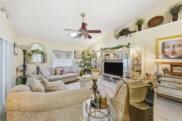 a living room with furniture kitchen view and a chandelier