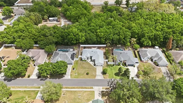 an aerial view of ocean and residential houses with outdoor space