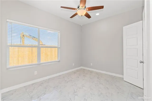 an empty room with a window and a fan