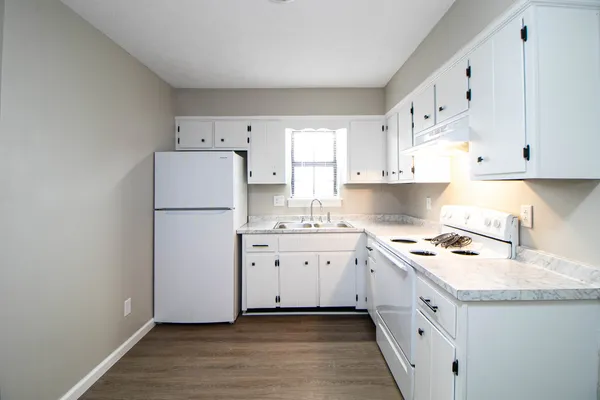 a kitchen with cabinets appliances a sink and a stove