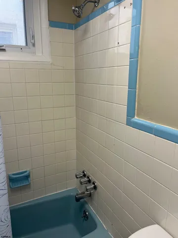 a white toilet sitting next to a white sink and vanity