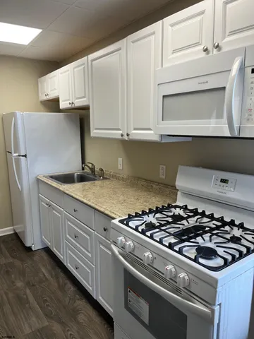 a kitchen with granite countertop white cabinets and a stove