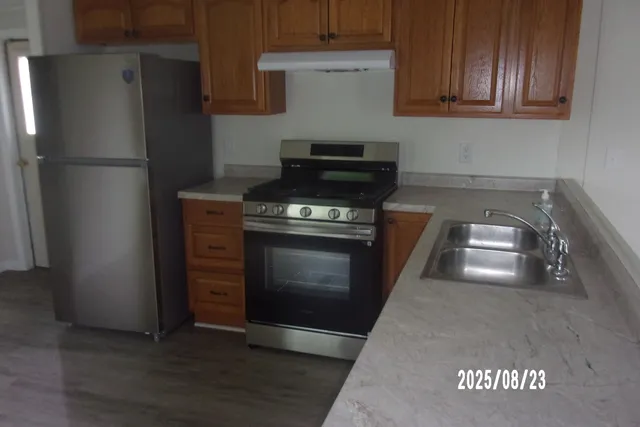 a kitchen with granite countertop a stove and a refrigerator