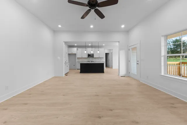 a view of wooden floor chandelier and window in a room