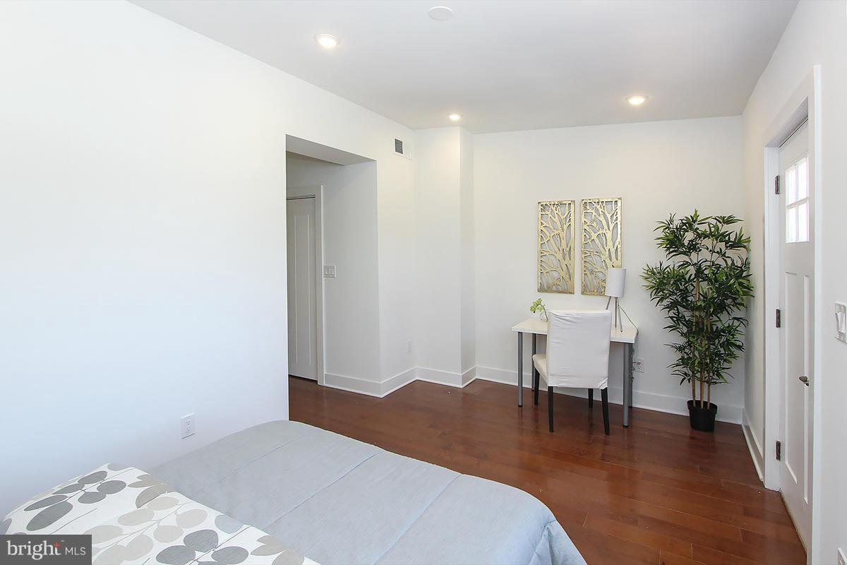 222 20th Street Northeast, Unit 1 Washington, DC 20002 - Photo 12 of 22 a bedroom with a bed and a table