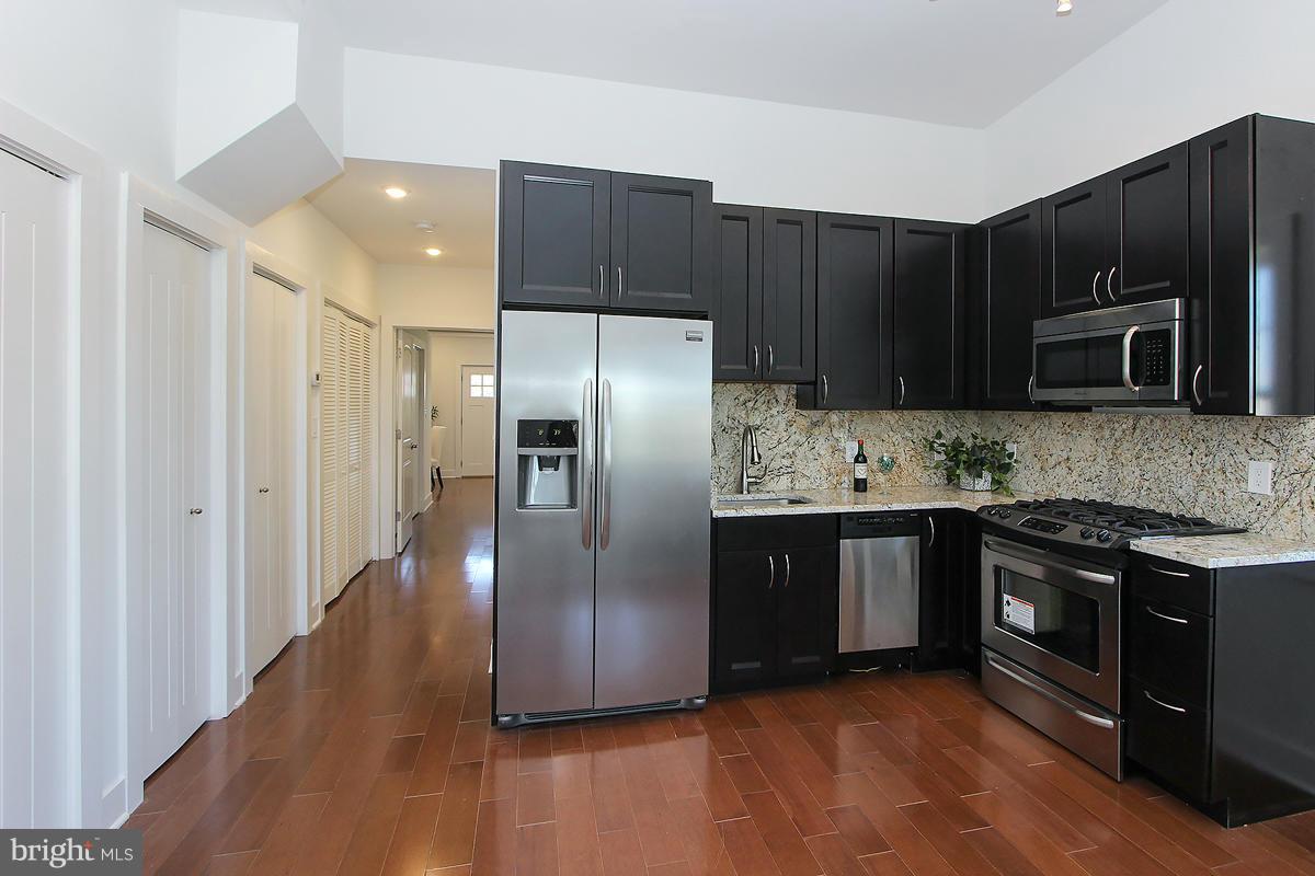 222 20th Street Northeast, Unit 1 Washington, DC 20002 - Photo 7 of 22 a kitchen with stainless steel appliances granite countertop a refrigerator and a stove top oven