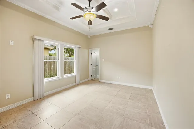 en empty room with windows and ceiling fan