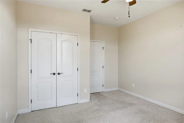 an empty room with windows and closet
