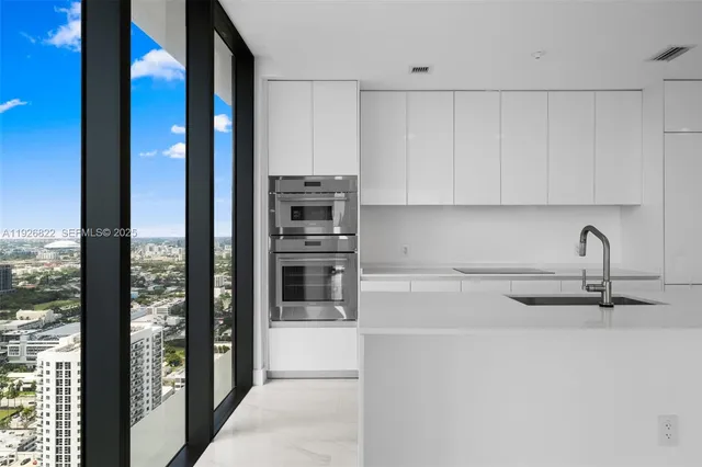 a view of a kitchen with refrigerator and windows