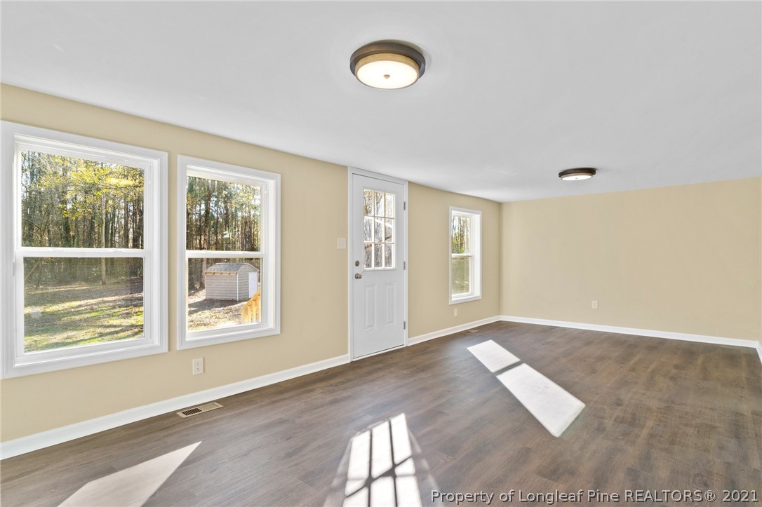 1650 Yellow Skin Road Autryville, NC 28318 - Photo 11 of 32 a view of an empty room with wooden floor and a window