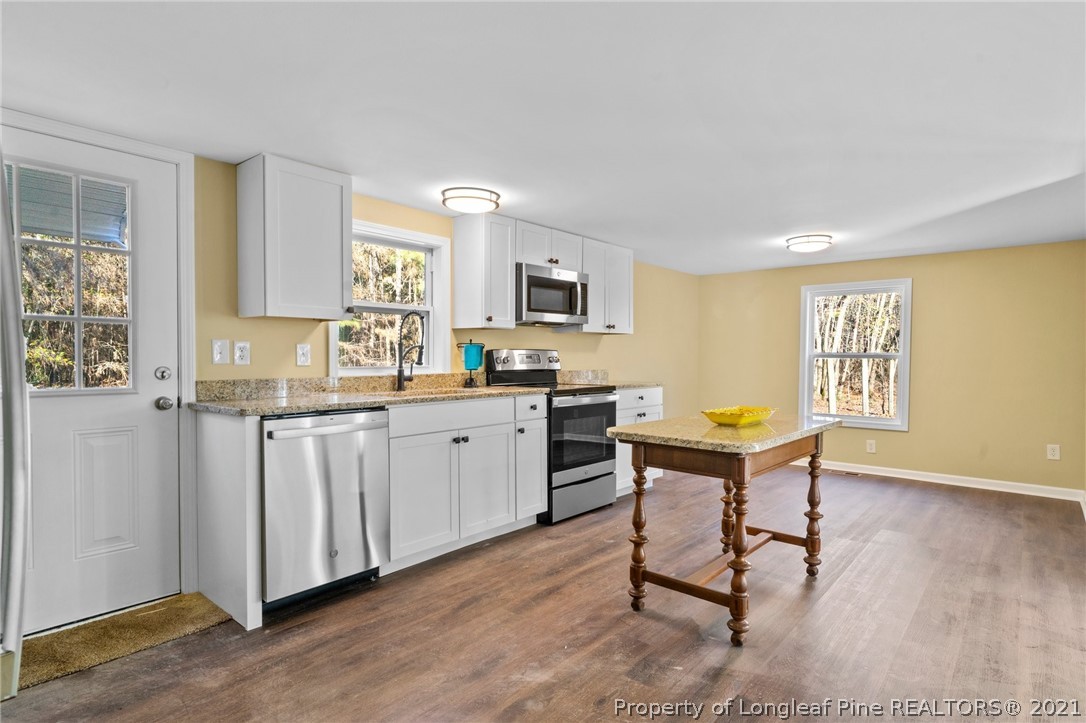1650 Yellow Skin Road Autryville, NC 28318 - Photo 13 of 32 a kitchen with sink cabinets and wooden floor