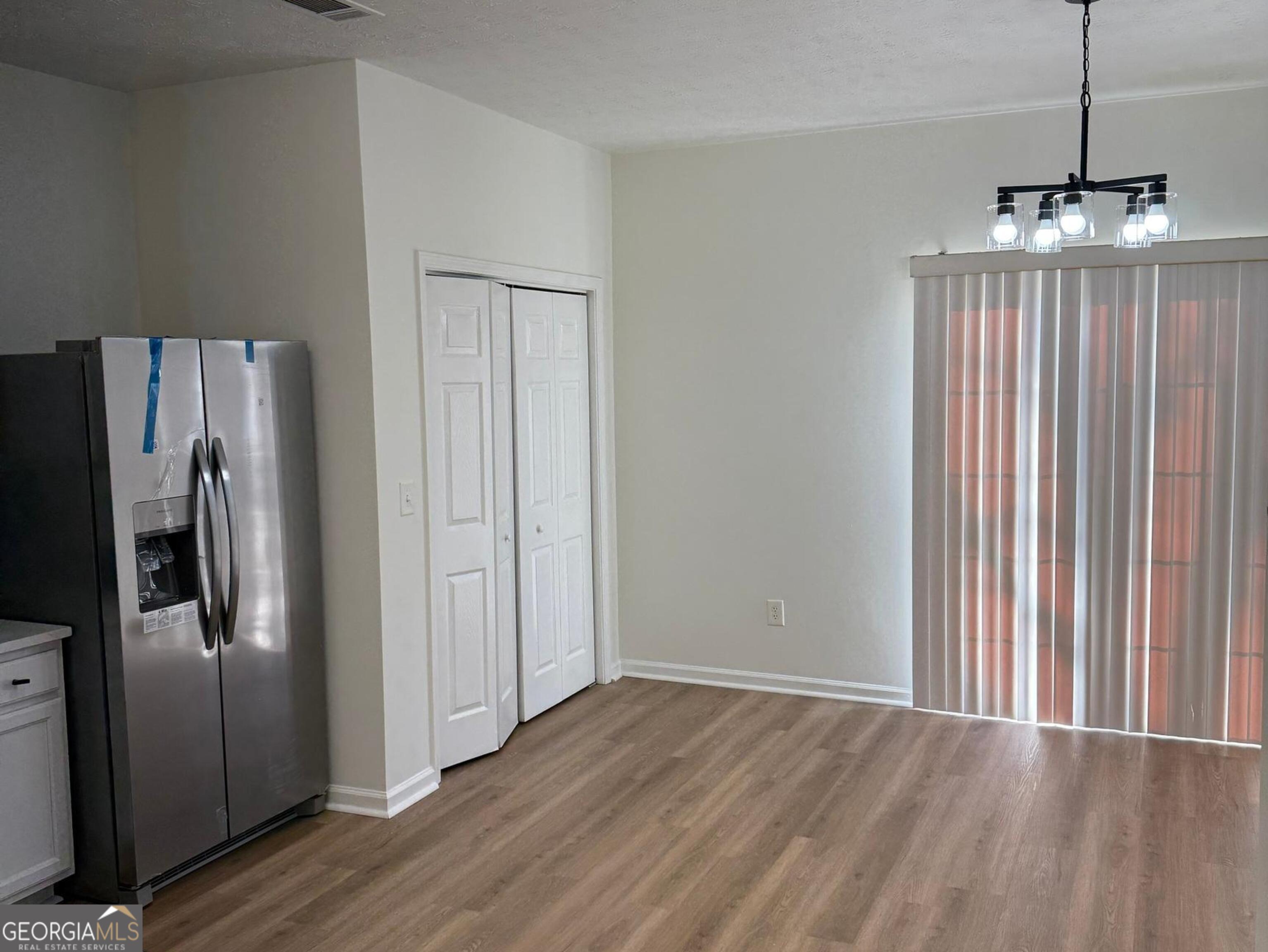 5471 Walnut Lane Lithonia, GA 30038 - Photo 14 of 40 a view of a kitchen with wooden floor fridge and a ceiling fan