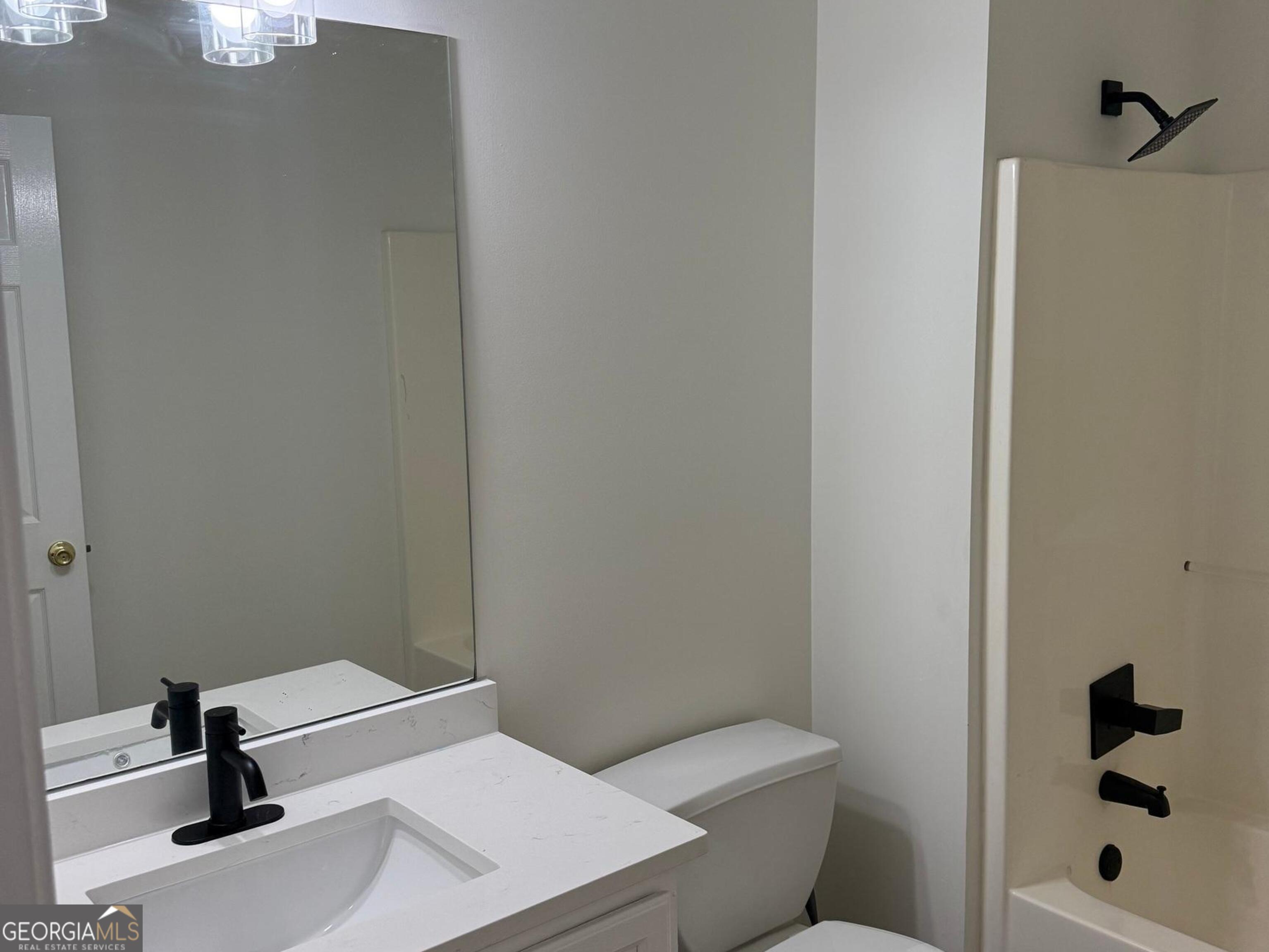 5471 Walnut Lane Lithonia, GA 30038 - Photo 35 of 40 a bathroom with a toilet a sink and shower