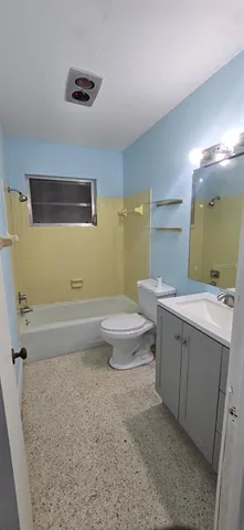 a bathroom with a granite countertop sink a toilet and mirror
