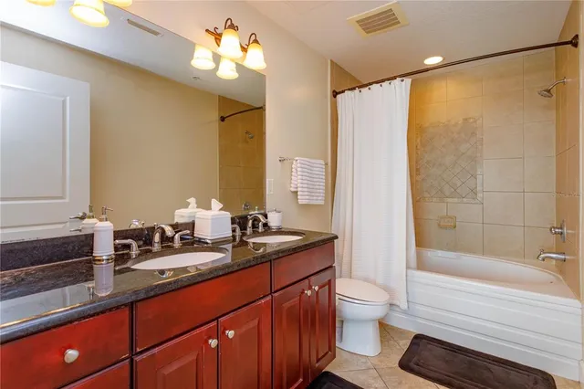 a bathroom with a double vanity sink toilet and shower