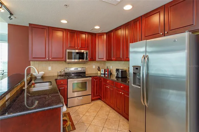 a kitchen with stainless steel appliances granite countertop a refrigerator stove a sink and dishwasher