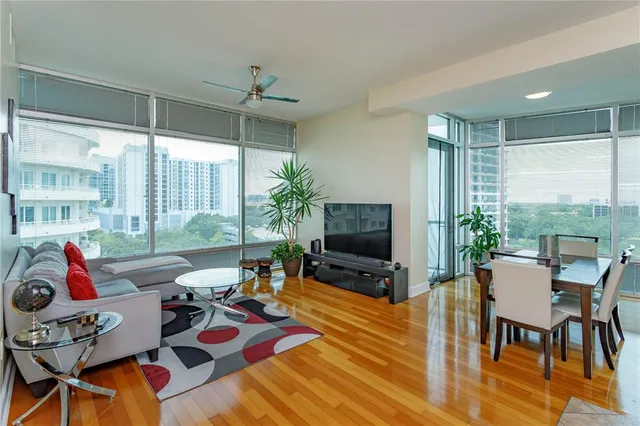 a living room filled with furniture windows and a flat screen tv