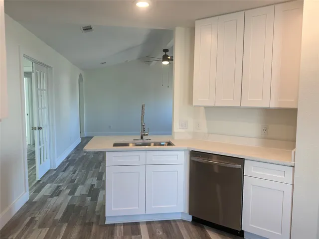 a kitchen with a sink cabinets and wooden floor