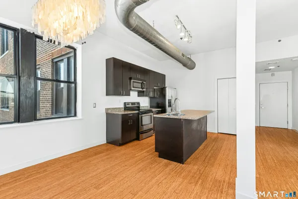 a kitchen with granite countertop a refrigerator and a sink