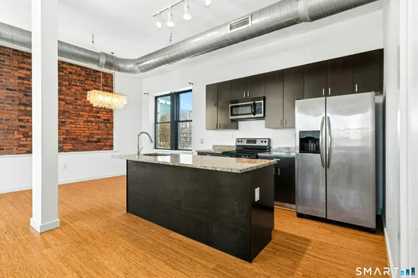 a kitchen with stainless steel appliances granite countertop a stove a sink and a refrigerator
