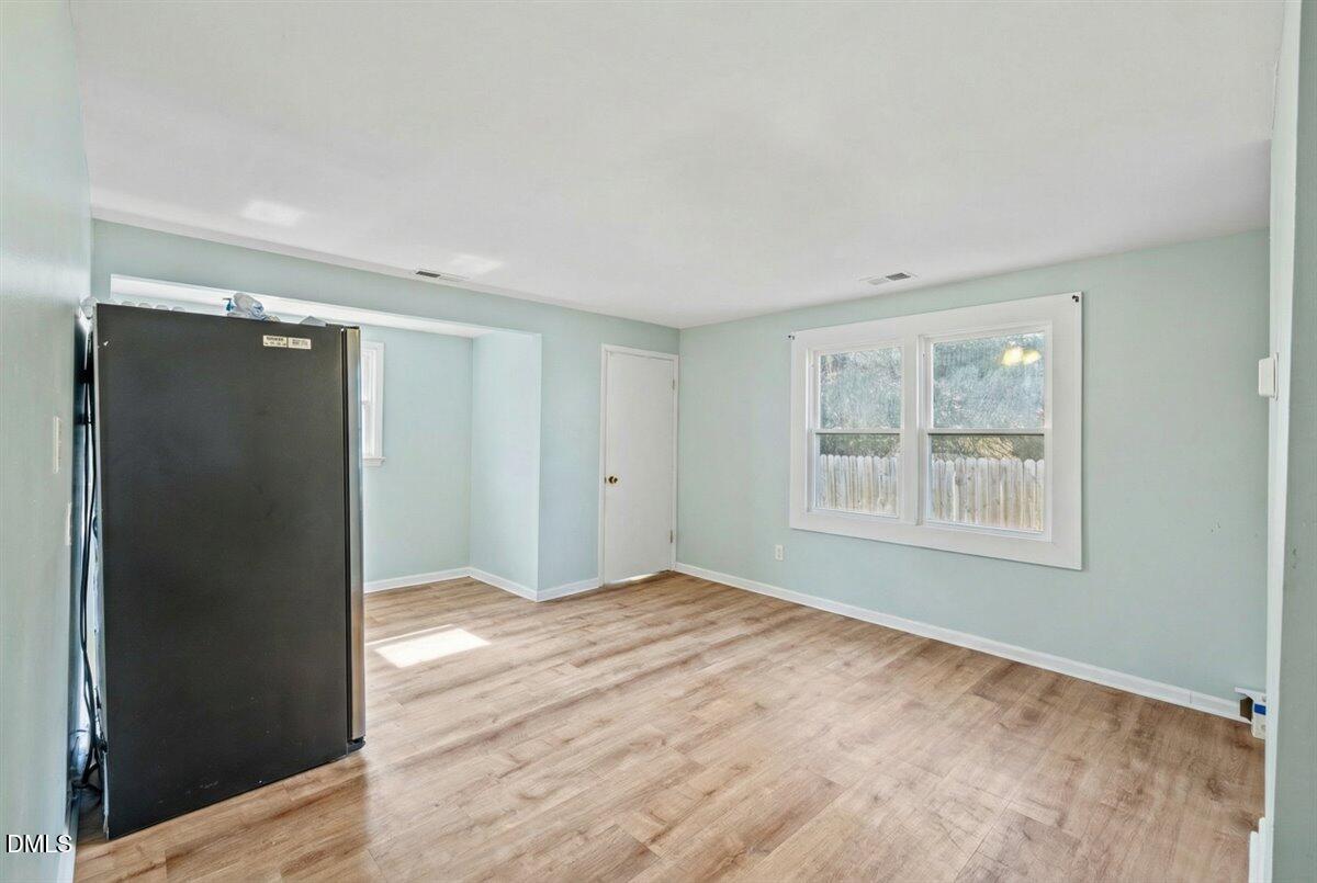 3133 Tryon Road Raleigh, NC 27603 - Photo 11 of 31 a view of an empty room with window and wooden floor