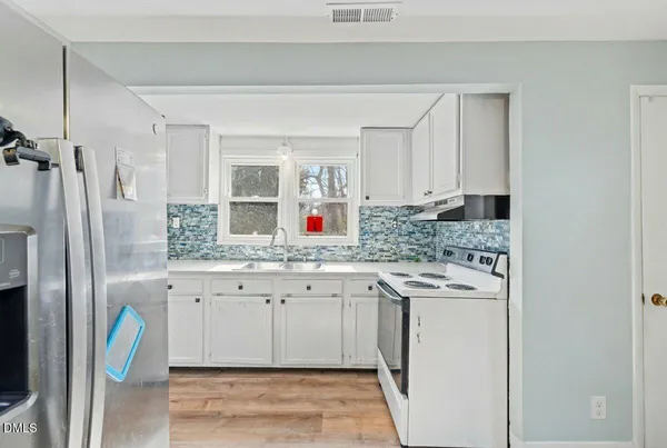 a kitchen with stainless steel appliances granite countertop a sink and refrigerator