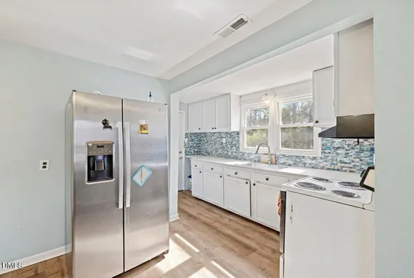 a kitchen with stainless steel appliances granite countertop a refrigerator and a stove top oven