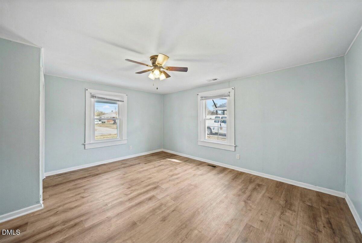 3133 Tryon Road Raleigh, NC 27603 - Photo 20 of 31 a view of an empty room with a window and wooden floor