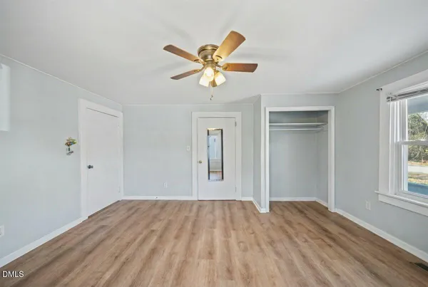 a view of empty room with wooden floor and window
