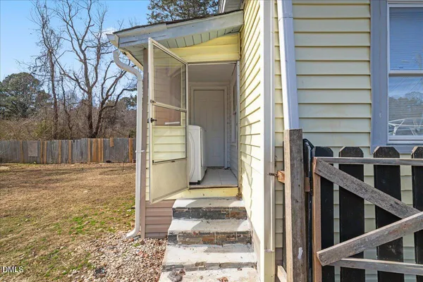 a view of a house with a door and wooden fence