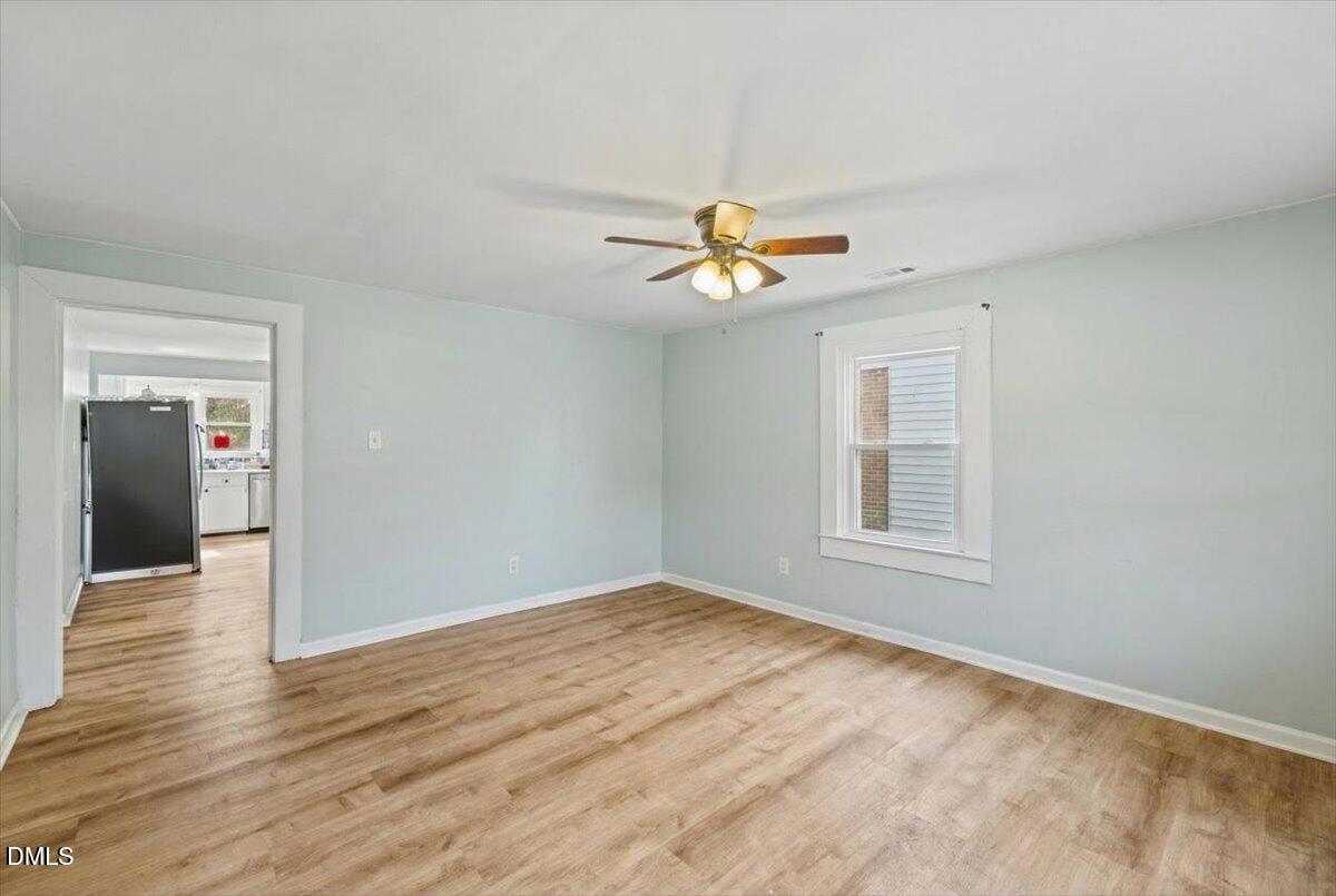 3133 Tryon Road Raleigh, NC 27603 - Photo 7 of 31 a view of an empty room with a window and wooden floor