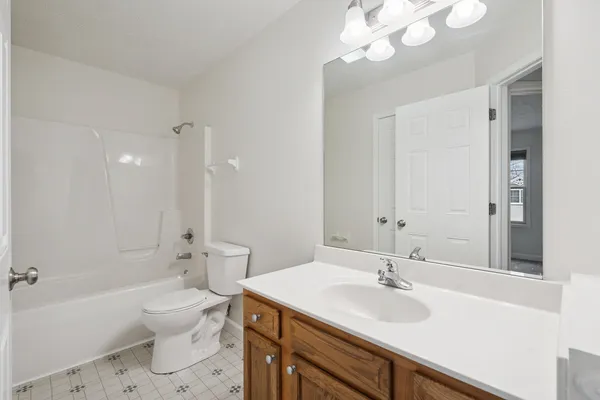 a bathroom with a sink a toilet a mirror and shower