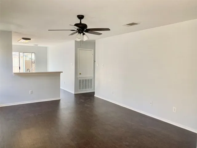 an empty room with a window and a ceiling fan
