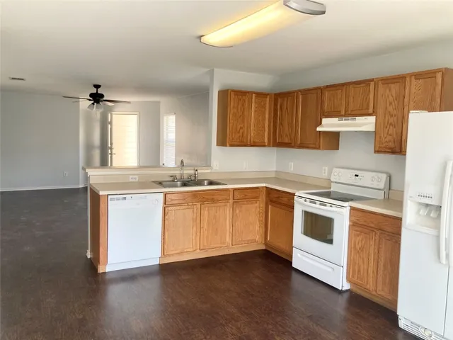 a kitchen with white cabinets and white appliances