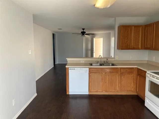a kitchen with granite countertop a sink and a stove top oven