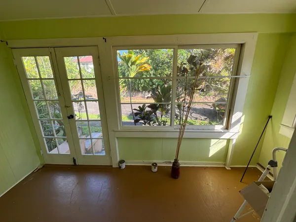 a view of an empty room with a floor to ceiling window and wooden floor