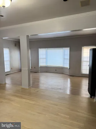 a view of a livingroom with wooden floor and staircase