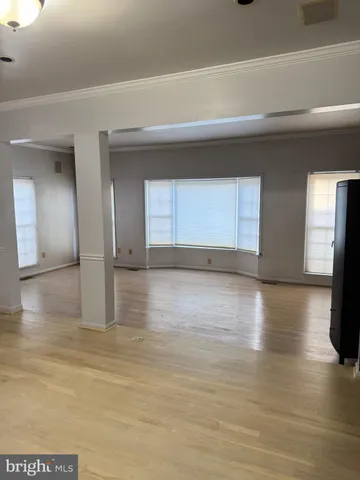 a view of a livingroom with wooden floor and staircase