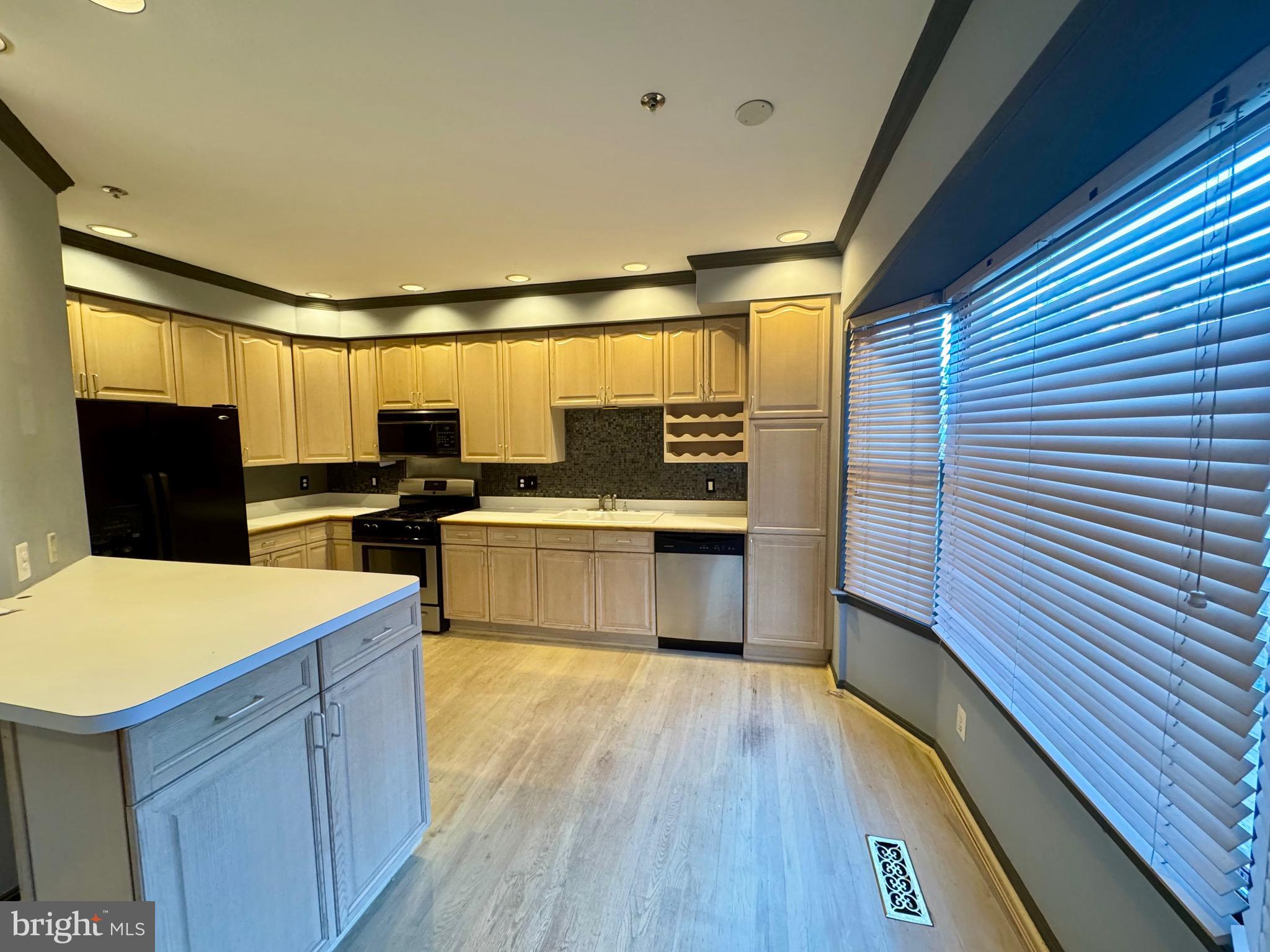 1713 Leighton Wood Lane Silver Spring, MD 20910 - Photo 25 of 47 a kitchen with stainless steel appliances wooden floor sink and wooden cabinets