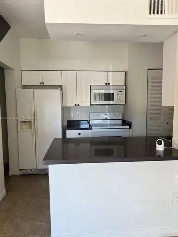 a kitchen with kitchen island a counter top space and cabinets