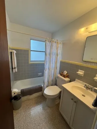 a bathroom with a sink a toilet a mirror and shower
