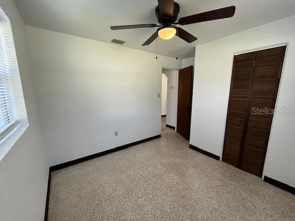 a view of a hallway with a ceiling fan