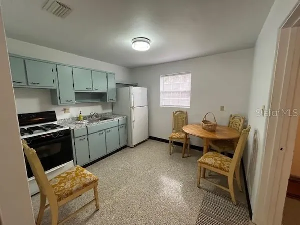 a kitchen with a refrigerator and a stove top oven