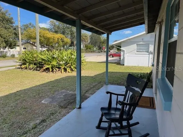 a view of a porch with chairs and backyard