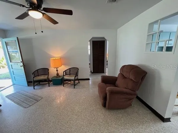 a living room with furniture and a air conditioner vent